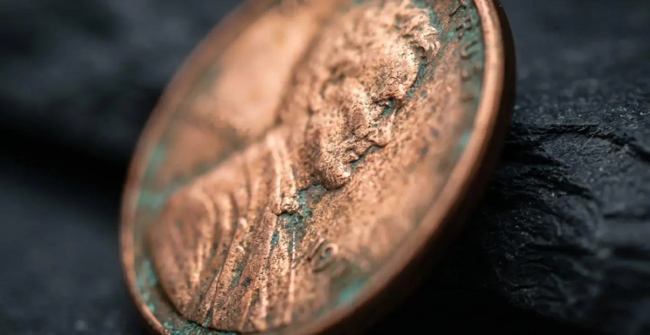 Extreme close-up macro shot of a tarnished copper coin on a dark surface, with a razor-thin slice in focus, symbolizing the volatility decay and narrow utility of inverse ETFs.